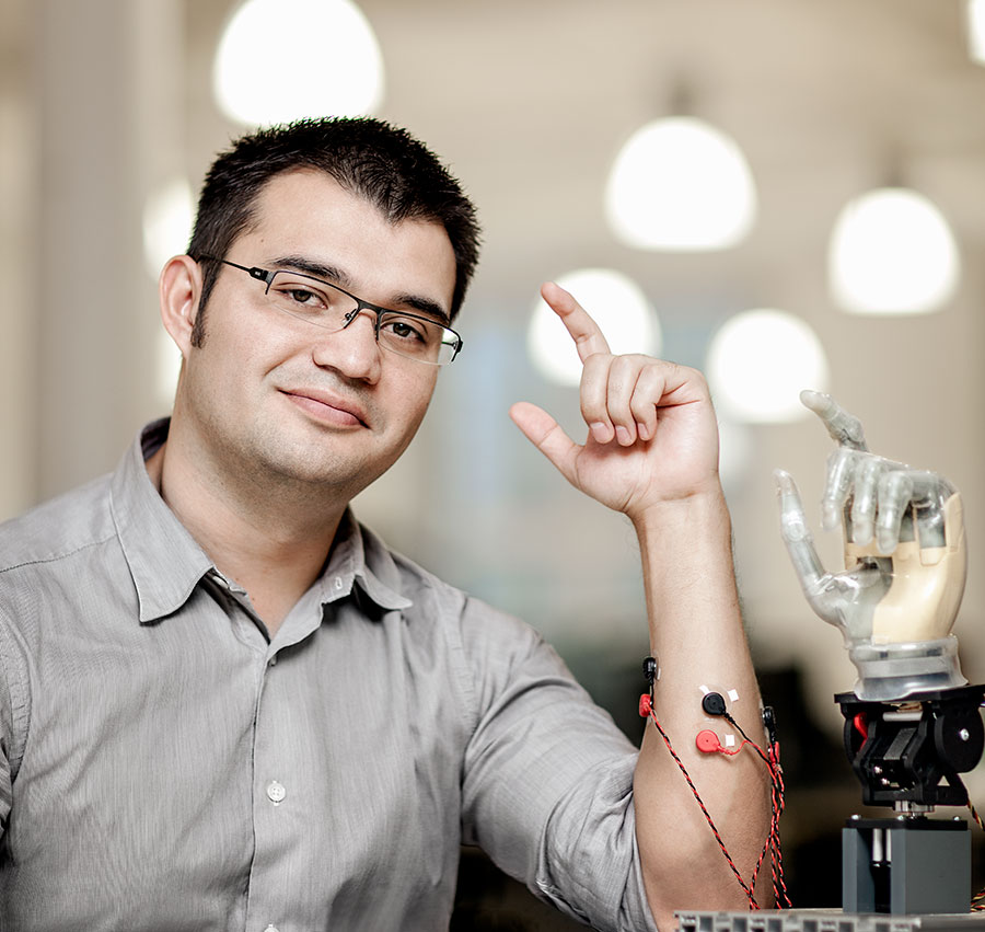 A professor with electrodes and a prosthetic limb pointing upwards